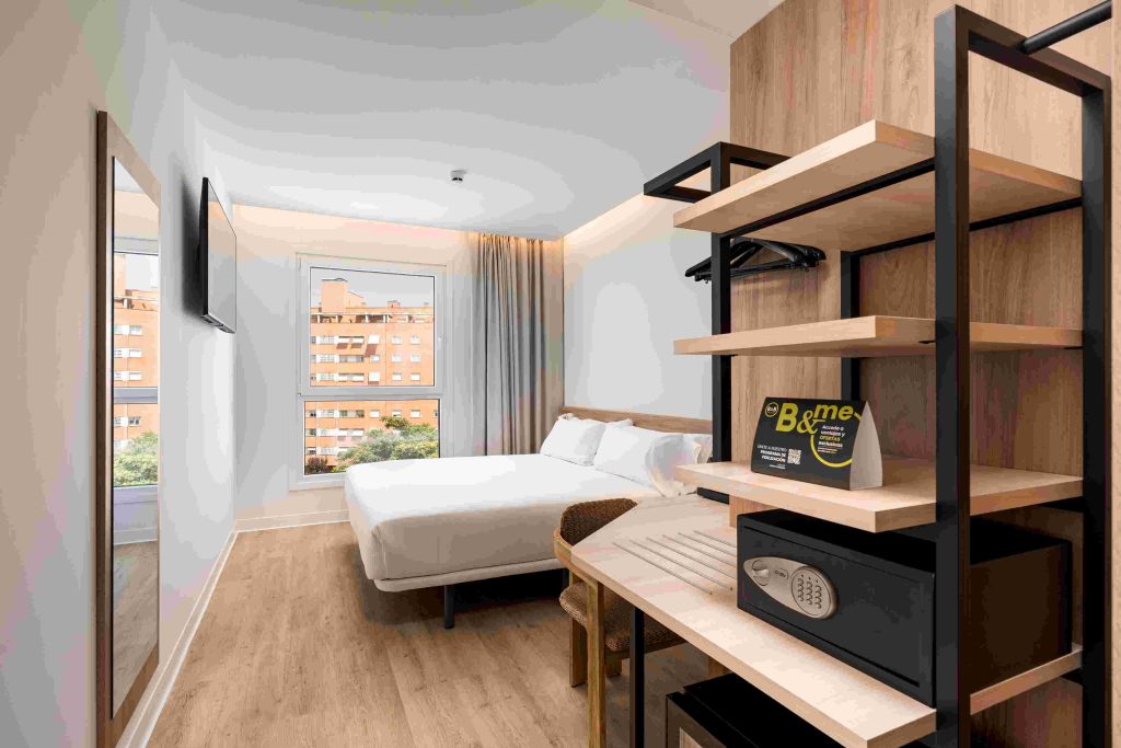 Bright, modern B&B HOTELS double room with wooden headboard and large window
