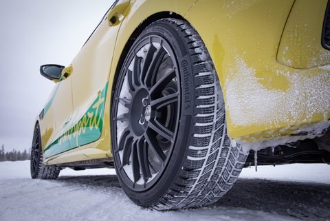 Car with a winter tyre on a snowy road