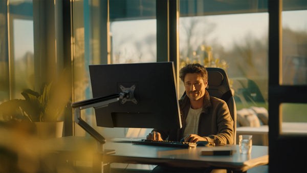 Monitor mounted on a Desktronic monitor arm above a desk
