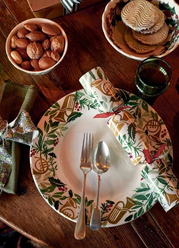Dress the Christmas Table, Piece by Piece, with Emma Bridgewater Emma Bridgewater Bring In The Green dinner plate on a Christmas table with nuts and candlelight