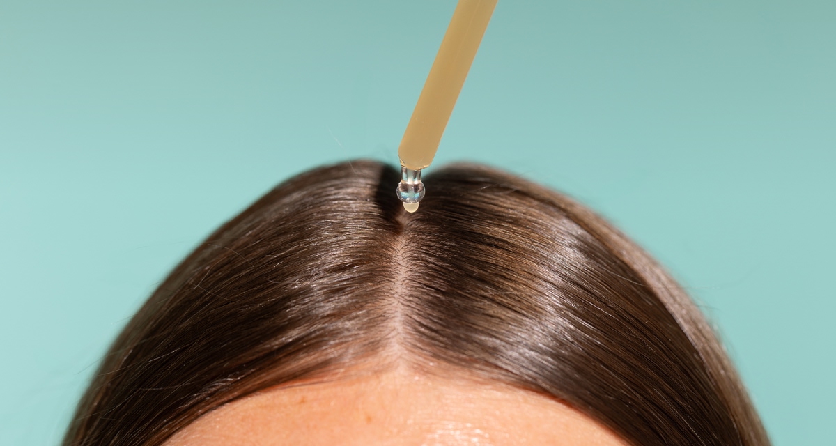 Applying Freshly Cosmetics hair growth treatment to the scalp