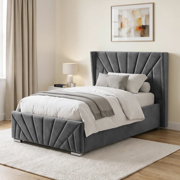 Grey velvet ottoman bed with a sunrise-pattern headboard and footboard