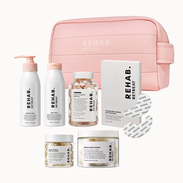 REHAB. Retreat: How to Build a Winter Body-Care Routine at Home REHAB. Retreat set with shower milk, body milk, body oil capsules, scrub jar and wash sheets beside a pink pouch