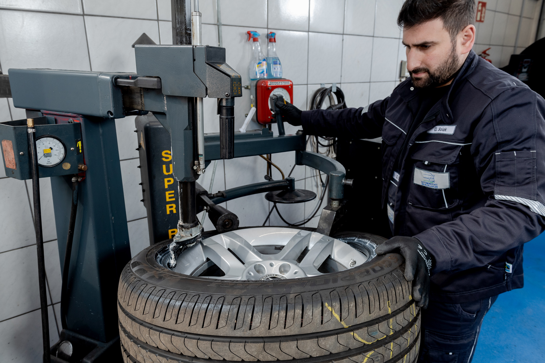 Technician fitting a new tyre on a tyre changing machine
