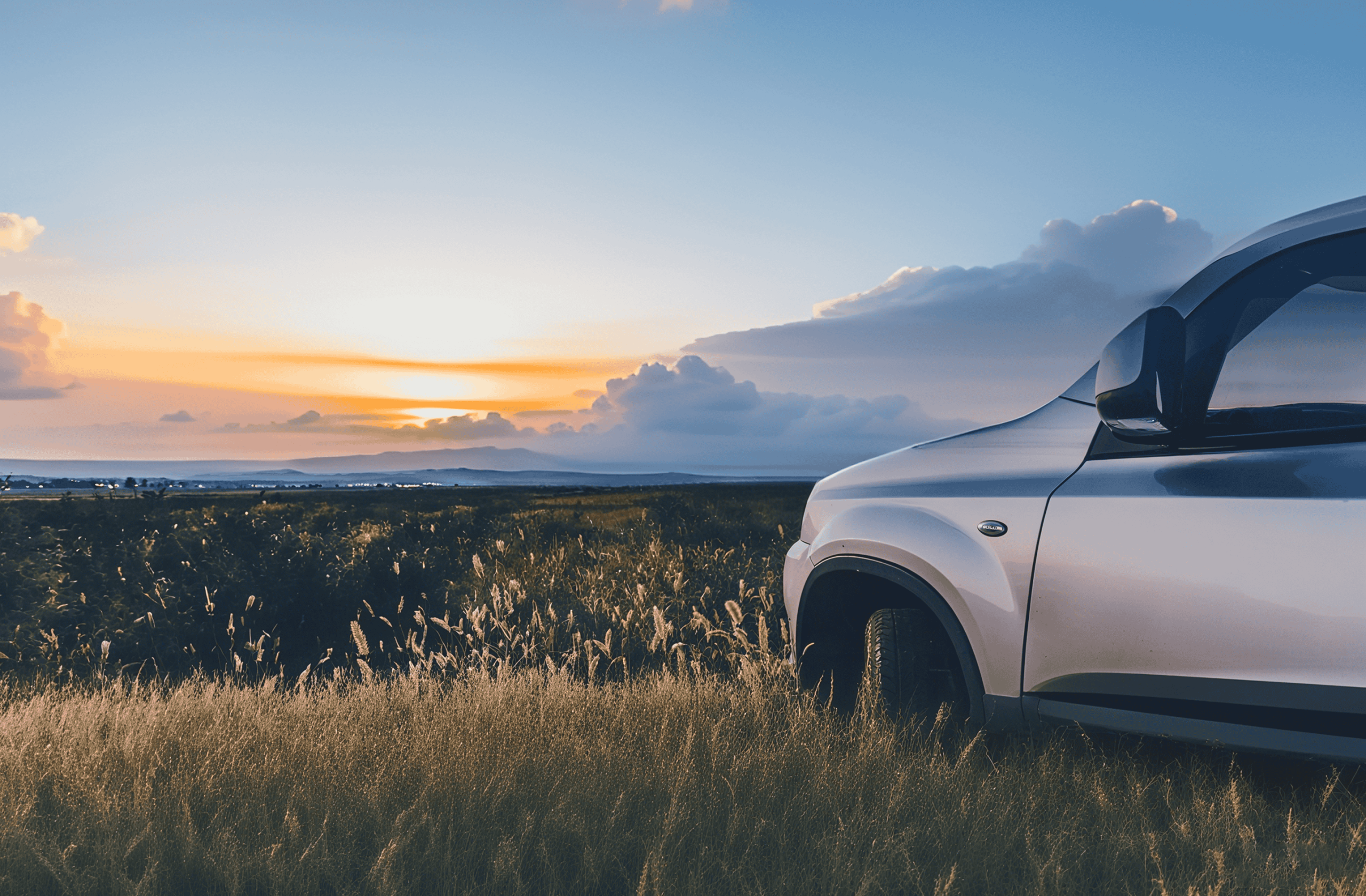 Rental car parked by a meadow at sunset - Trip.com car rentals